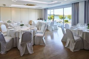 El elegante salón del Restaurante Marea Alta cuenta con mesas redondas con manteles y sillas blancas, ofreciendo un ambiente soleado y al aire libre, como el de Santander. Realce su celebración con el "Menú degustación en el restaurante Marea Alta (Santander)". - ForTwo - Planes para parejas