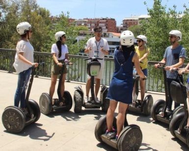 Un grupo con cascos, reunidos en círculo sobre Segways, comienza la soleada Ruta en Segway por Sevilla. - ForTwo - Planes para parejas