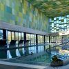 Ubicada en Zaragoza, la piscina cubierta del Club Ranillas presume de coloridas paredes de azulejos y amplios ventanales. Una pintoresca estatua de rana junto al agua realza la atmósfera serena de este oasis de spa, Día en el spa del Club Ranillas. - ForTwo - Planes para parejas