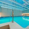 Una tranquila piscina cubierta de agua turquesa, bajo un techo de cristal y una iluminación suave, crea un ambiente de spa sereno en el Circuito de Spa & Masaje del Hotel Sallés Pere IV, Barcelona. - ForTwo - Planes para parejas