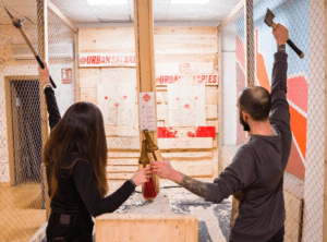 En la sesión de Tiro con Hacha de 1 hora, dos participantes apuntan hachas a objetivos en un área similar a una jaula, perfeccionando sus habilidades y desatando su leñador interior. - ForTwo - Planes para parejas