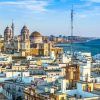 Disfrute del pintoresco paisaje urbano de Cádiz, con su Catedral, sus edificios blancos y su costa bajo un cielo azul. Explore su rica historia con la "Visita guiada por la historia de Cádiz" para vivir una experiencia inolvidable. - ForTwo - Planes para parejas