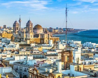 Disfrute del pintoresco paisaje urbano de Cádiz, con su Catedral, sus edificios blancos y su costa bajo un cielo azul. Explore su rica historia con la "Visita guiada por la historia de Cádiz" para vivir una experiencia inolvidable. - ForTwo - Planes para parejas