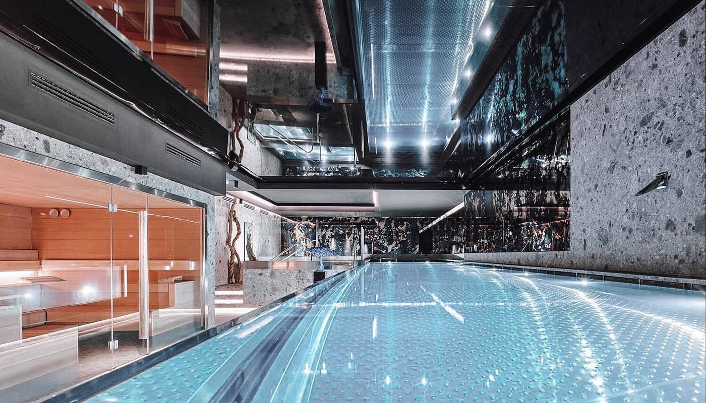 Descubra la lujosa piscina cubierta del Wellington Hotel & Spa de Madrid, con suelo de cristal y superficies de espejo que reflejan la luz ambiental. Mejore su visita con nuestro Circuito de Bienestar para rejuvenecer y relajarse. - ForTwo - Planes para parejas