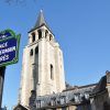 Placa de calle de la Place Saint-Germain des Prés con la torre de la iglesia al fondo bajo un cielo azul claro, que recuerda el encanto que se encuentra en un "Recorrido guiado por el Barrio Latino" gratuito en París. - ForTwo - Planes para parejas