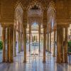 Explore el ornamentado patio de la Alhambra de Granada, con intrincados arcos y columnas enmarcados por arbustos verdes alrededor de una fuente central. Disfrute de un ambiente tranquilo bajo un cielo despejado con la "Visita guiada a la Alhambra con entrada incluida" para apreciar plenamente esta maravilla arquitectónica. - ForTwo - Planes para parejas