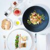 Un elegante montaje gastronómico para el "Masaje y almuerzo ejecutivo a la carta en el Hotel InterContinental Gran Vía (Madrid)" presenta dos platos gourmet, pan, aceite de oliva y condimentos sobre un mantel blanco impecable, perfecto para una experiencia refinada. - ForTwo - Planes para parejas