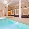 Experimente el ambiente sereno de Almuerzo con una lujosa piscina cubierta, cabañas, iluminación moderna y sauna en el hotel Yurbban en Barcelona, que ofrece masajes con aceite vegano para una relajación máxima. - ForTwo - Planes para parejas