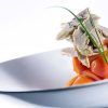Disfrute de una comida gourmet con rodajas de zanahoria naranja y tierna ave, elegantemente presentada en el Restaurante Ampar en el Palau de la Mar de Valencia. - ForTwo - Planes para parejas