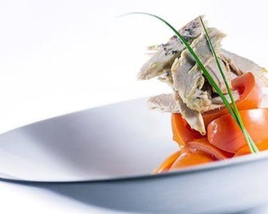 Disfrute de una comida gourmet con rodajas de zanahoria naranja y tierna ave, elegantemente presentada en el Restaurante Ampar en el Palau de la Mar de Valencia. - ForTwo - Planes para parejas