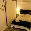 Acogedor dormitorio en Apartamento para 2 en el centro de Granada con cama de matrimonio, dos lámparas pequeñas, arte de pared y toallas dobladas sobre la colcha. - ForTwo - Planes para parejas