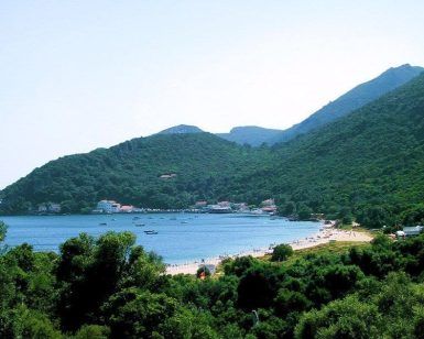 Disfrute de la vista panorámica de la Bahía de Sesimbra con una playa, barcos en el agua y las exuberantes montañas verdes de Arrábida con Enoturismo por Arrábida y Sesimbra. - ForTwo - Planes para parejas