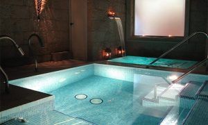 Disfrute de una lujosa experiencia de spa interior para dos, completa con piscinas iluminadas, pasamanos de metal e iluminación ambiental, ideal para un relajante Spa para dos con opción a envoltura o masaje en Madrid. - ForTwo - Planes para parejas