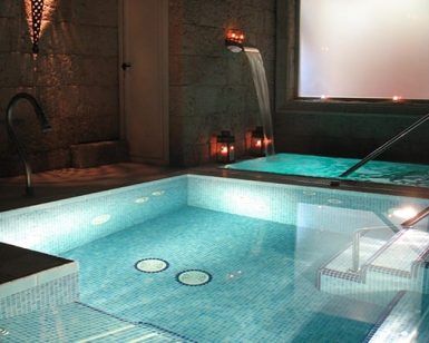 Disfrute de una lujosa experiencia de spa interior para dos, completa con piscinas iluminadas, pasamanos de metal e iluminación ambiental, ideal para un relajante Spa para dos con opción a envoltura o masaje en Madrid. - ForTwo - Planes para parejas