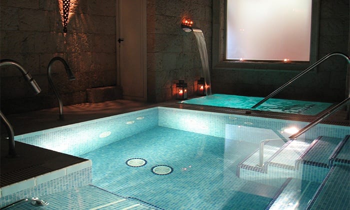Disfrute de una lujosa experiencia de spa interior para dos, completa con piscinas iluminadas, pasamanos de metal e iluminación ambiental, ideal para un relajante Spa para dos con opción a envoltura o masaje en Madrid. - ForTwo - Planes para parejas