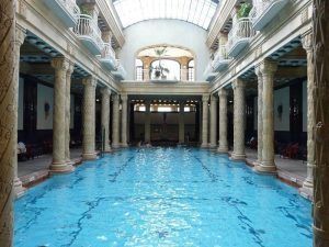Experimente la encantadora piscina cubierta del Balneario Gellért en Budapest, adornada con columnas ornamentadas y un alto techo abovedado, bellamente rodeada de barandillas en los balcones. Disfrute de todo esto con la Entrada al Balneario Gellért sin colas (Budapest). - ForTwo - Planes para parejas