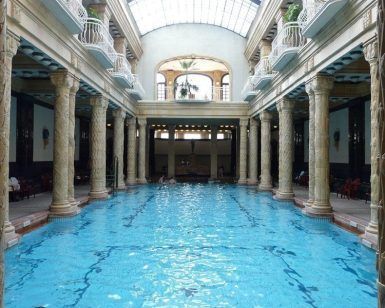 Experimente la encantadora piscina cubierta del Balneario Gellért en Budapest, adornada con columnas ornamentadas y un alto techo abovedado, bellamente rodeada de barandillas en los balcones. Disfrute de todo esto con la Entrada al Balneario Gellért sin colas (Budapest). - ForTwo - Planes para parejas