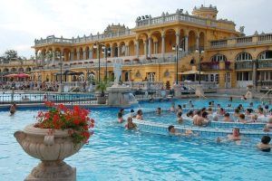 Experimente la grandeza del histórico Balneario Széchenyi de Budapest, donde los huéspedes disfrutan de una gran piscina al aire libre rodeada de elegantes arcos y columnas. Reserve su "Entrada al Balneario Széchenyi sin colas" para sumergirse en este oasis atemporal sin esperas. - ForTwo - Planes para parejas