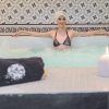 Una mujer en bikini disfruta del mejor ambiente de spa en Hammam y Jacuzzi en Le Patio Spa, con gorro de ducha, velas y toalla: un entorno perfecto para la relajación. - ForTwo - Planes para parejas