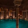 La piscina cubierta elegantemente tenue en Hammam Al Ándalus Málaga, rodeada de arcos y azulejos intrincados, presenta la experiencia exclusiva "Exclusivo MIDRA en Hammam Al Ándalus Málaga". - ForTwo - Planes para parejas