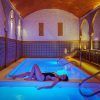Relajarse junto a una piscina cubierta iluminada con techo abovedado y azulejos decorativos se siente como entrar en el Baño árabe para dos con masaje completo en Medina Aljarafe (Sevilla), que ofrece una escapada serena. - ForTwo - Planes para parejas
