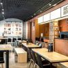 El moderno interior de la cervecería cuenta con mesas y sillas de madera y una acogedora zona de bar. Los amplios ventanales iluminan el cartel de Barcelona Beer Company, creando un ambiente ideal para disfrutar de la "Cata de cervezas y quesos artesanos" (Barcelona) con cervezas y quesos artesanales. - ForTwo - Planes para parejas