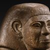 Un antiguo busto de piedra con tocado y expresión solemne, sobre un fondo oscuro, se puede ver con una Entrada al Museo Egipto (Barcelona). - ForTwo - Planes para parejas