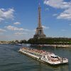 La Vuelta en barco por el río Sena (París) ofrece impresionantes vistas de la ciudad, pasando sin esfuerzo junto a la Torre Eiffel bajo un cielo adornado con nubes dispersas. - ForTwo - Planes para parejas