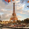 Contra un cielo nublado de París, "Descubre París en barco y bus y visita la Torre Eiffel" captura la majestuosa vista mientras los barcos se deslizan por el Sena enmarcados por hojas de otoño. - ForTwo - Planes para parejas