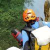 Escalando rocas con un casco naranja y un traje de neopreno azul, alguien abraza la emoción del barranquismo en Granada en el impresionante Barranco de Lentegí's, cerca de aguas cristalinas. - ForTwo - Planes para parejas
