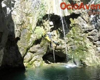 Un aventurero desciende en rápel por una cascada hasta una tranquila poza rocosa entre los escarpados acantilados de Jorox. Esta aventura con Barranquismo en Jorox de la mano de Ocio Aventura (Málaga) captura la esencia del ocio aventura en un entorno impresionante. - ForTwo - Planes para parejas