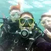 Tres buceadores con trajes de neopreno y gafas posan para un selfie grupal durante su "Bautizo de buceo con Freeandivers (Barcelona). - ForTwo - Planes para parejas