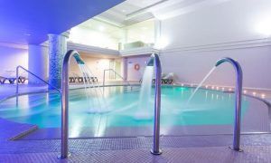 Sumérjase en una experiencia de piscina cubierta en Adeje, completa con cascadas de agua y tumbonas bajo una relajante iluminación azul, ideal para relajarse después de disfrutar del Circuito spa para 2 personas con opción de masaje. - ForTwo - Planes para parejas