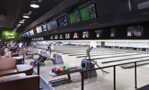 Gente disfrutando de múltiples pistas y bolas de colores en Bolera en Bowling Madrid - Chamartín, creando un ambiente animado. - ForTwo - Planes para parejas