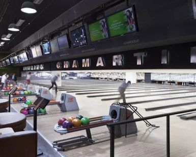 Gente disfrutando de múltiples pistas y bolas de colores en Bolera en Bowling Madrid - Chamartín, creando un ambiente animado. - ForTwo - Planes para parejas
