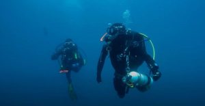 En el profundo mar azul de Castro Urdiales, Cantabria, dos buceadores con trajes de neopreno y equipo de buceo se deslizan elegantemente mientras experimentan su Bautismo de buceo en Castro Urdiales (Cantabria). - ForTwo - Planes para parejas