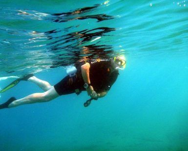 En medio de las brillantes aguas de Granada, una persona explora el vibrante mundo submarino con un cómodo traje de neopreno y un confiable snorkel desde "Salida de buceo snorkel desde barco en la costa de Granada", deslizándose sin esfuerzo con aletas a través de profundidades azules cristalinas. - ForTwo - Planes para parejas