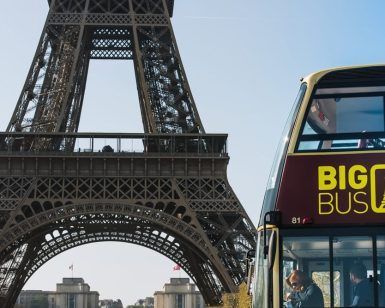 Una majestuosa Entrada para el bus turístico de París se encuentra frente a la Torre Eiffel bajo un cielo azul claro. - ForTwo - Planes para parejas