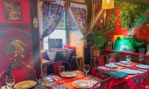 El Restaurante Noches de Moscú en Madrid crea un ambiente cálido y acogedor con su colorido interior, completo con mesas brillantes, decoración vibrante, cortinas y exuberante vegetación para complementar perfectamente el Menú ruso para dos. - ForTwo - Planes para parejas