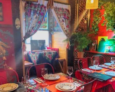 El Restaurante Noches de Moscú en Madrid crea un ambiente cálido y acogedor con su colorido interior, completo con mesas brillantes, decoración vibrante, cortinas y exuberante vegetación para complementar perfectamente el Menú ruso para dos. - ForTwo - Planes para parejas