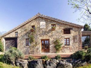 Ca la Maria, en Llagostera, Tarragona, es una encantadora casa rural de piedra con puertas de madera, pequeñas ventanas y hiedra. Rodeada de vegetación y un cielo azul despejado, encarna la filosofía slow food de KM0 a través de su Menú degustación slow food km0. - ForTwo - Planes para parejas