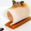 En el Restaurante Bouquet de Cáceres, saborea una delicia gourmet con una concha enrollada rellena de mousse, cubierta con microgreens y caviar sobre una base de masa rectangular. - ForTwo - Planes para parejas
