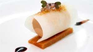 En el Restaurante Bouquet de Cáceres, saborea una delicia gourmet con una concha enrollada rellena de mousse, cubierta con microgreens y caviar sobre una base de masa rectangular. - ForTwo - Planes para parejas