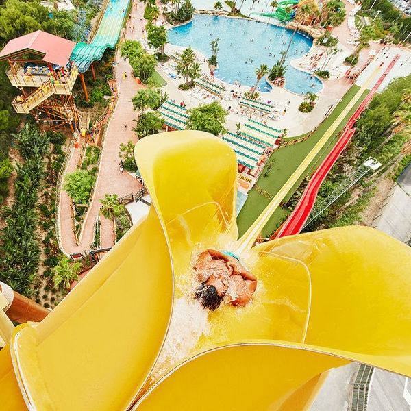 Un emocionante paseo por el gran tobogán acuático amarillo de Caribe Aquatic Park, rodeado de la exuberante vegetación de Port Aventura, crea un día inolvidable en Tarragona con Entradas para el parque acuático Caribe Aquatic Park de Port Aventura (Tarragona). - ForTwo - Planes para parejas