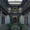 Este patio histórico, que hace eco de la elegancia de las Casas Nazaríes, cuenta con balcones de madera, plantas en macetas y un camino central que conduce a un arco, que recuerda a la Granada histórica: Explora los palacios y Casas Nazaríes frente a la Alhambra (Granada). - ForTwo - Planes para parejas