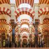 Explora el impresionante interior de la Mezquita-Catedral de Córdoba, donde los arcos rayados rojos y blancos coronan los pilares de mármol. Para una visión más profunda, considere el "Tour guiado con entradas: Mezquita-Catedral (Córdoba). - ForTwo - Planes para parejas