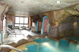 Relájese en un spa interior con diseño tipo cueva, con piscina, cómodos sillones y una iluminación relajante que recuerda al Circuito spa y parrillada para dos en El Cercado de la Alpujarra. Los amplios ventanales ofrecen vistas apacibles para una relajación total. - ForTwo - Planes para parejas