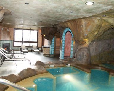 Relájese en un spa interior con diseño tipo cueva, con piscina, cómodos sillones y una iluminación relajante que recuerda al Circuito spa y parrillada para dos en El Cercado de la Alpujarra. Los amplios ventanales ofrecen vistas apacibles para una relajación total. - ForTwo - Planes para parejas