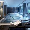 Lujoso spa interior en Valencia que cuenta con el Circuito Spa Primus 80 minutos de relax, que ofrece piscina, tumbonas, toallas y relajantes chorros de agua con paredes grises diseñadas por Primus e iluminación suave para una escapada serena. - ForTwo - Planes para parejas