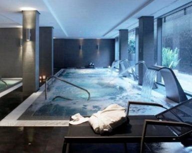 Lujoso spa interior en Valencia que cuenta con el Circuito Spa Primus 80 minutos de relax, que ofrece piscina, tumbonas, toallas y relajantes chorros de agua con paredes grises diseñadas por Primus e iluminación suave para una escapada serena. - ForTwo - Planes para parejas